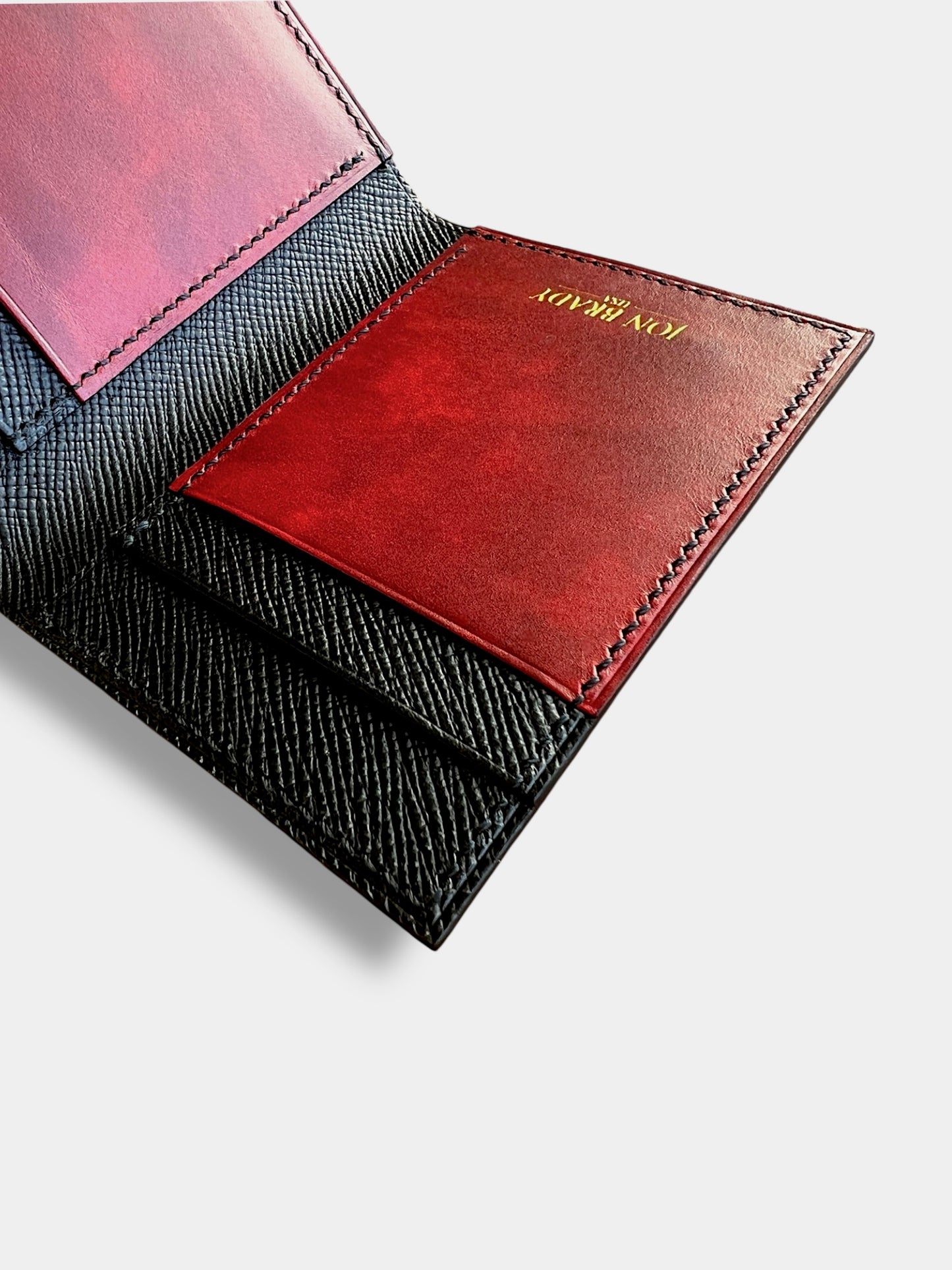 Close-up of a wallet with a red leather patch and visible jon brady usa logo